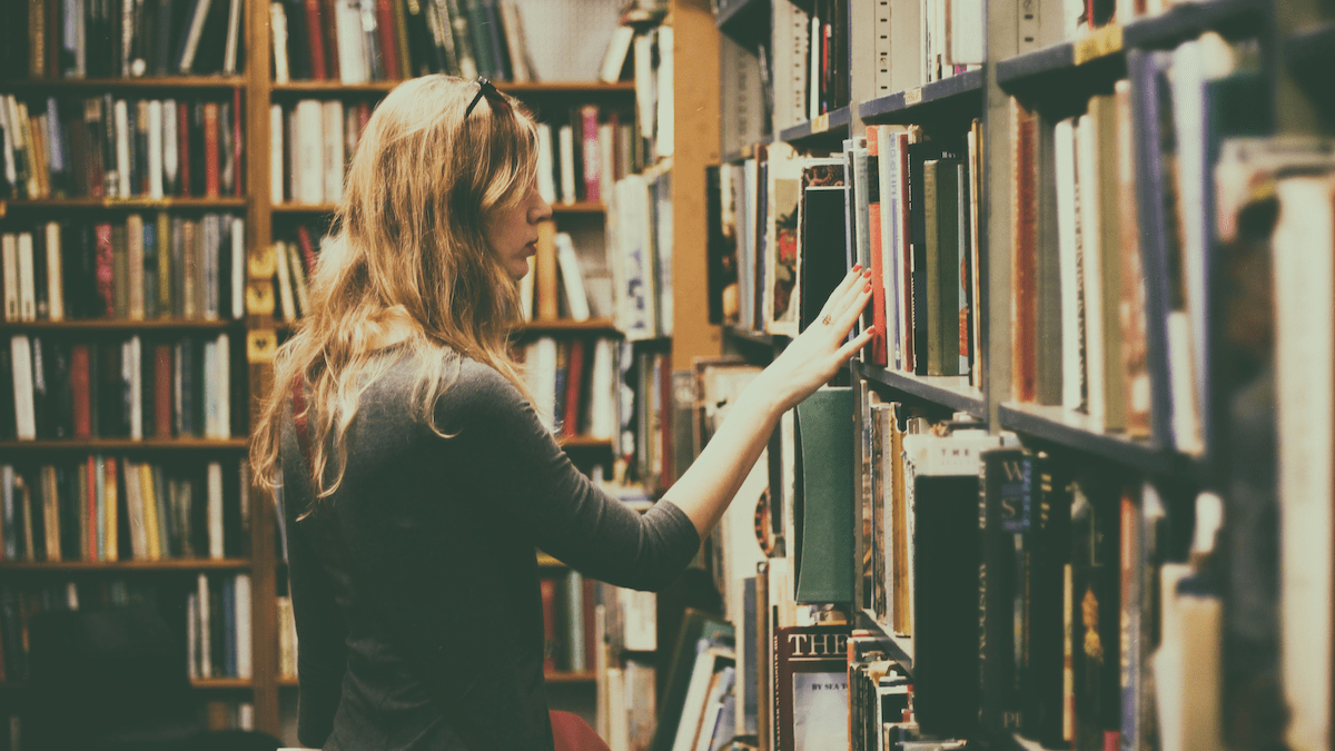 https://www.pexels.com/photo/woman-in-black-long-sleeved-looking-for-books-in-library-926680/